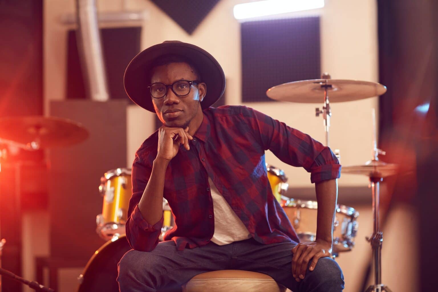 Musician posing for photo in front of music equipment in Edmonton thanks to Good Company Entertainment Group's artist support and management services